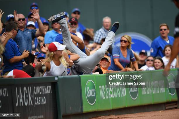 Tommy La Stella of the Chicago Cubs goes head over heals into the crowd as he makes the catch of a fly ball in the first inning against the Chicago...