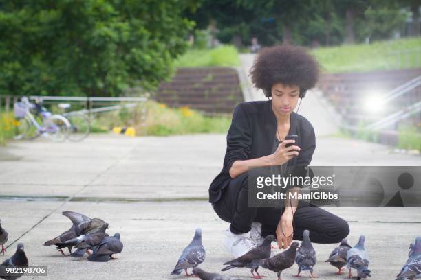 young man is working on  smartphone at the park - mamigibbs imagens e fotografias de stock