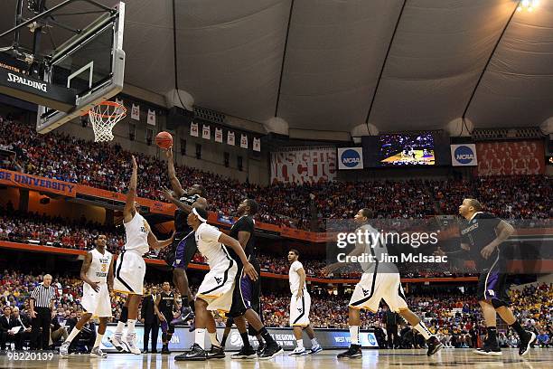 Justin Holiday of the Washington Huskies attempts a shot against the West Virginia Mountaineers during the east regional semifinal of the 2010 NCAA...