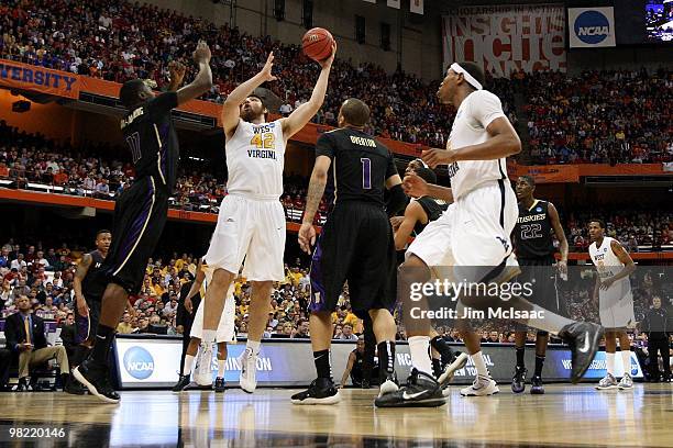 Deniz Kilicli of the West Virginia Mountaineers attempts a shot against Matthew Bryan-Amaning of the Washington Huskies during the east regional...