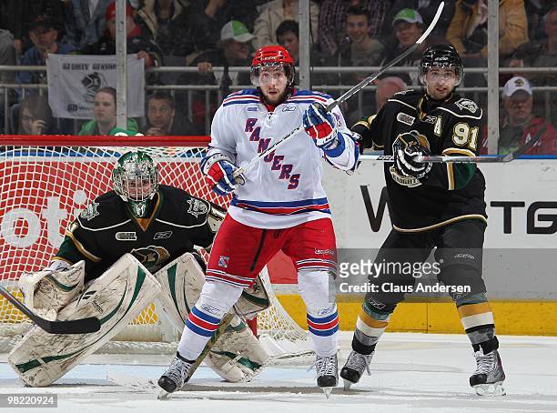 Julian Cimadamore of the Kitchener Rangers waits to tip a shot between Michael Hutchinson and Nazem Kadri of the London Knights in the first game of...