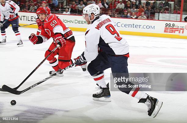 Chad LaRose of the Carolina Hurricanes attempts to knock Bredndan Morrison of the Washington Capitals off the puck during the NHL game on March 18,...
