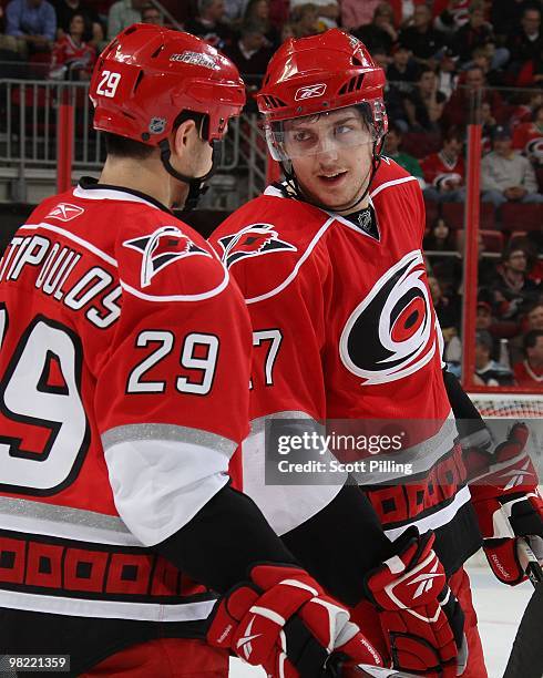 Brett Carson of the Carolina Hurricanes chats with Tom Kostopolous during an intermission during the NHL game against the Washington Capitals on...