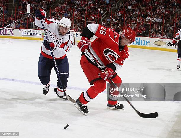 Erik Cole of the Carolina Hurricanes batles for a loose puck with Tomas Fleischmann of the Washington Capitals during the NHL game on March 18, 2010...