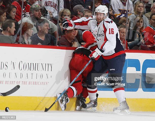 Eric Fehr of the Washington Capitals puts one of the Carolina Hurricanes into the boards during the NHL game on March 18, 2010 at the RBC Center in...