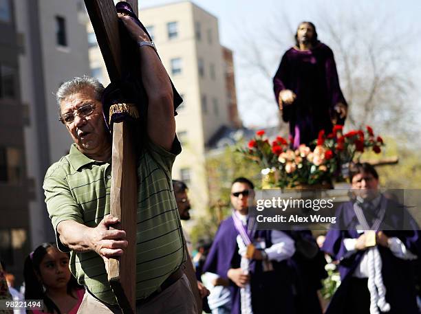 Local resident Mariano Aguero carries a cross in a "Via Crucis" procession, also known as walk in the footsteps of Christ, on Good Friday, April 2,...