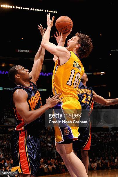 Pau Gasol of the Los Angeles Lakers puts a shot up over C.J. Watson and Chris Hunter of the Golden State Warriors during the game on February 16,...