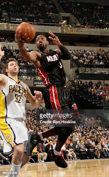 Dwyane Wade of the Miami Heat lays the ball up on Josh McRoberts of the Indiana Pacers at Conseco Fieldhouse on April 2, 2010 in Indianapolis,...
