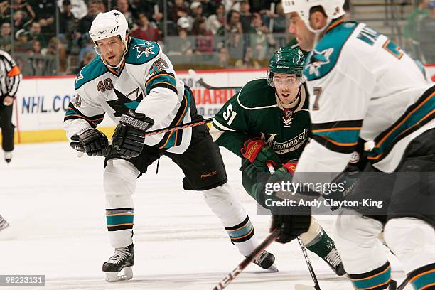 James Sheppard of the Minnesota Wild and Kent Huskins of the San Jose Sharks skate to the puck during the game at the Xcel Energy Center on April 2,...