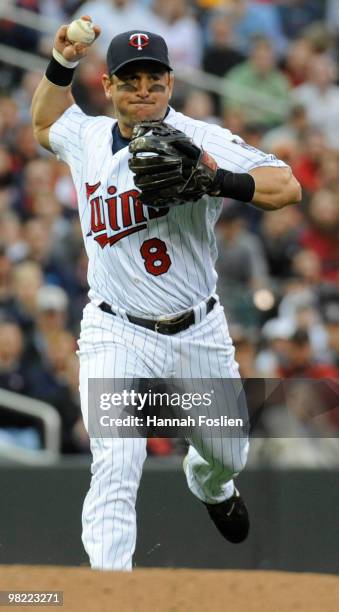 Nick Punto of Minnesota Twins throws to first in the third inning against the St. Louis Cardinals during an exhibition game at Target Field on April...