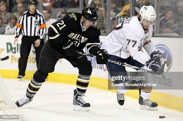 Tom Gilbert of the Edmonton Oilers skates the puck past Loui Eriksson of the Dallas Stars at American Airlines Center on April 2, 2010 in Dallas,...