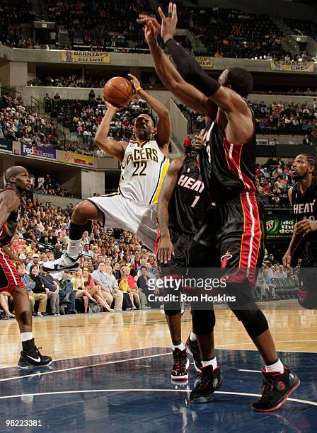 Price of the Indiana Pacers shoots over Dorell Wright of the Miami Heat at Conseco Fieldhouse on April 2, 2010 in Indianapolis, Indiana. The Heat...
