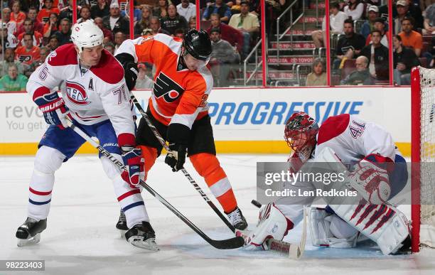 Jaroslav Halak of the Montreal Canadiens makes a save with Hal Gill and James van Riemsdyk of the Philadelphia Flyers waiting for a rebound on April...