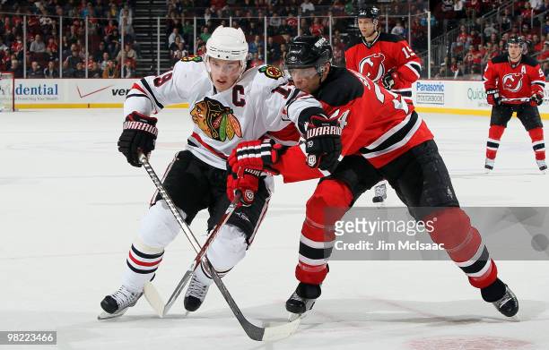 Jonathan Toews of the Chicago Blackhawks tries to skate past Bryce Salvador of the New Jersey Devils at the Prudential Center on April 2, 2010 in...