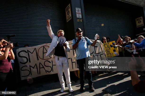 Performance artist, activist and mayoral candidate Reverend Billy holds the speaker as immigrant-rights activist Ravi Ragbir speaks during a...