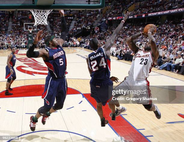 LeBron James of the Cleveland Cavaliers tries to get a shot off over Josh Smith and Marvin Williams of the Atlanta Hawks on April 2, 2010 at the...