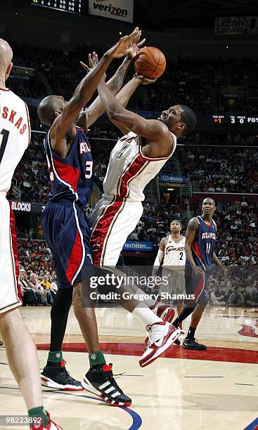 Leon Powe of the Cleveland Cavaliers tries to get a shot off over Joe Smith of the Atlanta Hawks on April 2, 2010 at the Quicken Loans Arena in...