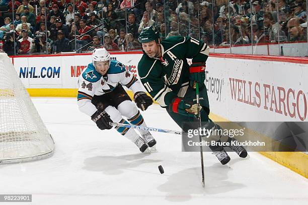 Owen Nolan of the Minnesota Wild skates with the puck while Marc-Edouard Vlasic of the San Jose Sharks defends during the game at the Xcel Energy...