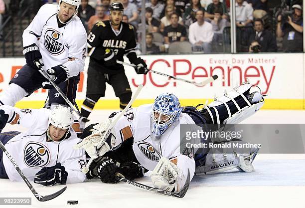 Goaltender Devan Dubnyk of the Edmonton Oilers dives for the puck with Loui Eriksson of the Dallas Stars and Dean Arsene at American Airlines Center...