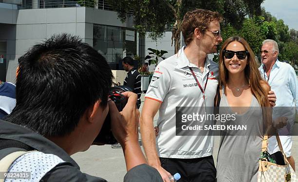 Photographer takes pictures of McLaren-Mercedes driver Jenson Button of Britain with his girlfriend Jessica Michibata on the paddock prior to the...