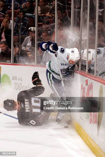 Corey Perry of the Anaheim Ducks falls to the ice after colliding with Andrew Alberts of the Vancouver Canucks during the game on April 2, 2010 at...