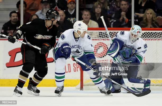 Goaltender Andrew Raycroft of the Vancouver Canucks makes a save in front of teammate Andrew Alberts and Teemu Selanne of the Anaheim Ducks in the...