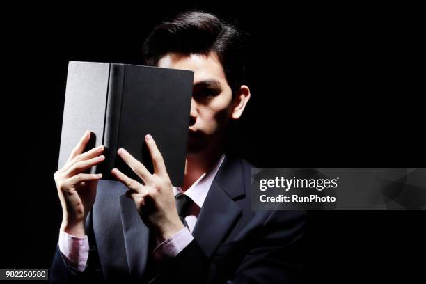 businessman covering face with book - obscured face ストックフォトと画像