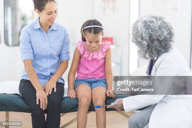 primaire-âge fille assise à la table d’examen pour un bilan de santé - table dexamen médical photos et images de collection