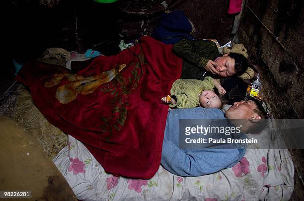 Nandintsetseg and Baigalnaa with son Munkhorgil, 18 months, wake up sharing a bed inside the small sewer where the family lives March 15, 2010 in...