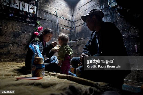 Nandintsetseg feeds their son Munkhorgil, 18 months, before going to work, as father, Baigalnaa watches living inside the small sewer that the family...