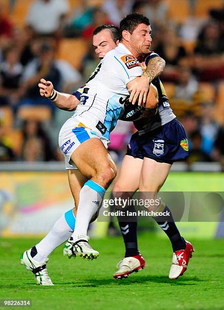 Mark Minichiello of the Titans skips out of the tackle of Shannon Gallant of the Cowboys on his way to score the first try of the match during the...