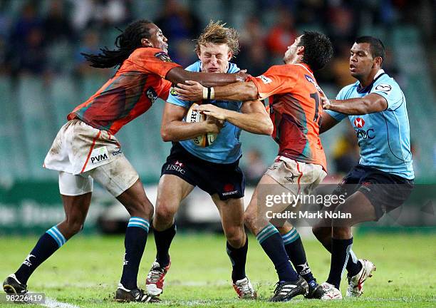 Lachie Turner of the Waratahs is tackled during the round eight Super 14 match between the Waratahs and the Cheetahs at Sydney Football Stadium on...