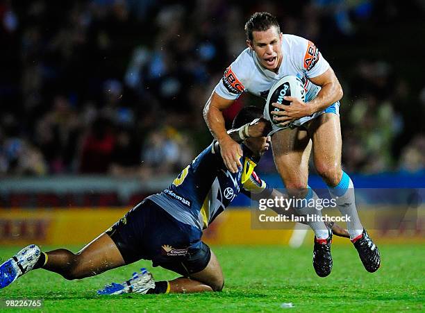 William Zillman of the Titans skips out of a tackle of Ray Thompson of the Cowboys during the round four NRL match between the North Queensland...