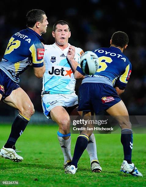 Greg Bird of the Titans gets a kick away despite the defence of Luke O'Donnell and Ray Thompson of the Cowboys during the round four NRL match...