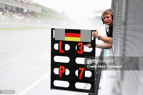Tommi Parmakoski, trainer to Sebastian Vettel of Germany and Red Bull Racing holds lap boards on the pitwall during qualifying for the Malaysian...
