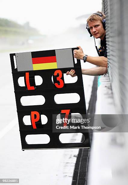 Tommi Parmakoski, trainer to Sebastian Vettel of Germany and Red Bull Racing holds lap boards on the pitwall during qualifying for the Malaysian...