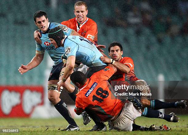 Berrick Barnes of the Waratahs is tackled during the round eight Super 14 match between the Waratahs and the Cheetahs at Sydney Football Stadium on...