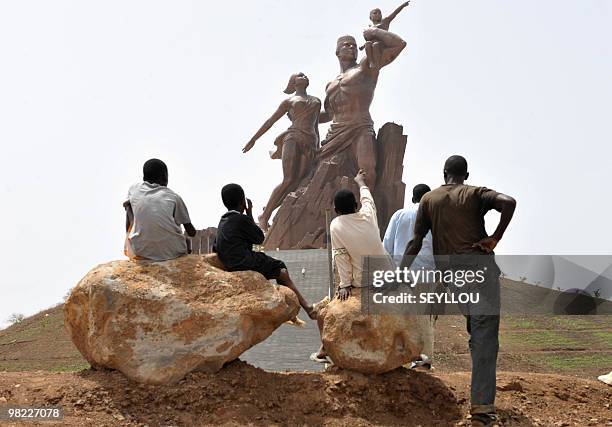 Children look at the "African Renaissance Monument" on April 1, 2010 in Dakar during preparations for the April 3 inauguration where heads of states...