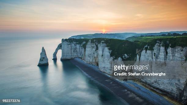 cliffs above the sea at sunset in etretat, normandy, france - normandy stock-fotos und bilder