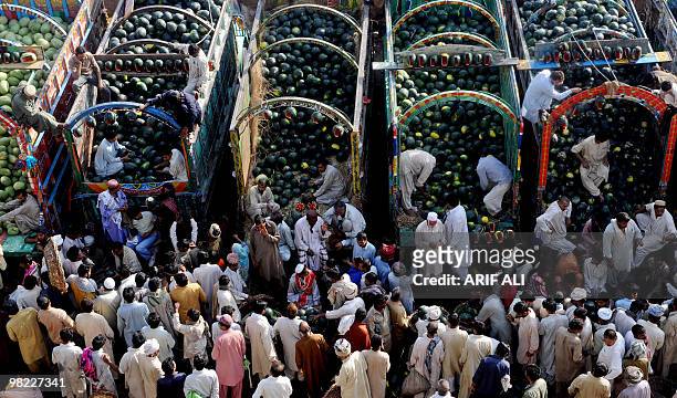 Pakistani farmers sit on truck loaded with watermelon as they bargain with dealers at a fruit market in Lahore on April 3, 2010. Last fiscal year,...
