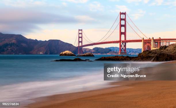 a beach next to the golden gate bridge in san francisco, california, usa - golden gate fotografías e imágenes de stock