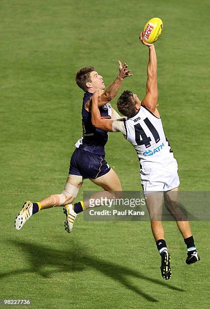 Jason Davenport of the Power attempts to mark the ball in front of Beau Waters of the Eagles during the round two AFL match between the West Coast...