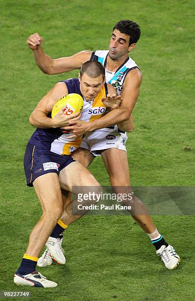 Eric Mackenzie of the Eagles gets tackled by Domenic Cassisi of the Power during the round two AFL match between the West Coast Eagles and Port...
