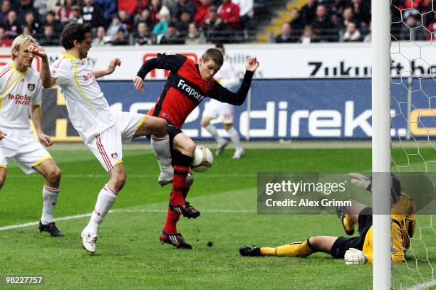 Manuel Friedrich of Leverkusen tries to score against Sebastian Jung and goalkeeper Oka Nikolov of Frankfurt during the Bundesliga match between...