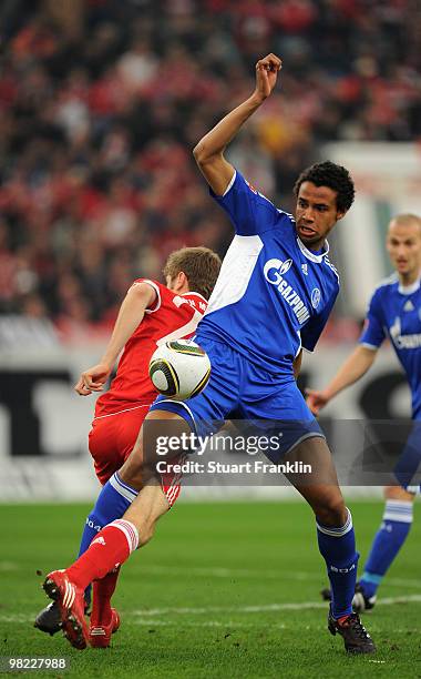 Thomas Mueller of Bayern is challenged by Joel Matip of Schalke during the Bundesliga match between FC Schalke 04 and FC Bayern Muenchen at the...