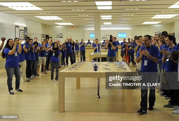 Employees clap as the first customers for the iPad enter the Apple Store at West Farms Mall in Farmington, Connecticut, on April 3, 2010. Customers...