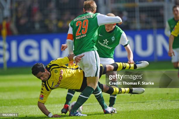 Per Mertesacker and Petri Pasanen of Bremen tackle Lucas Barrios of Dortmund during the Bundesliga match between Borussia Dortmund and SV Werder...