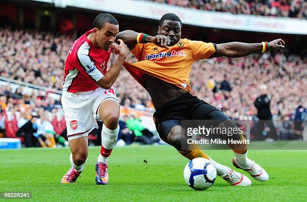 Theo Walcott of Arsenal is challenged by George Elokobi of Wolverhampton Wanderers during the Barclays Premier League match between Arsenal and...