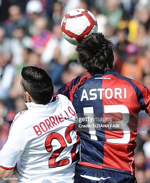 Milan's forward Marco Borriello jumps for the ball against Cagliari's defender Davide Astori during their Italian Serie A football match against...