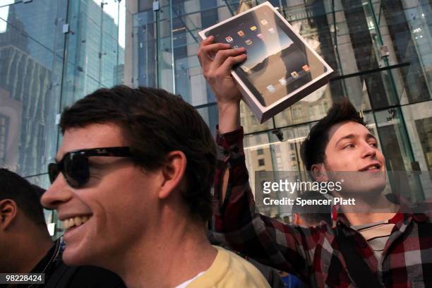 An early customer emerges from the Apple store on Fifth Avenue with Apple Inc's new iPad on April 3, 2010 in New York City. Hundreds lined up in...